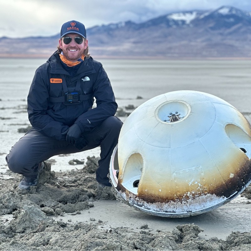 Kristofer Stone with a returned spacecraft capsule